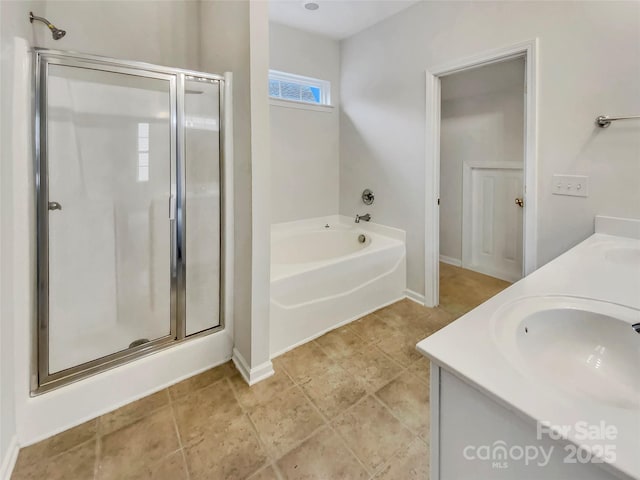 full bath featuring double vanity, a stall shower, a garden tub, and a sink