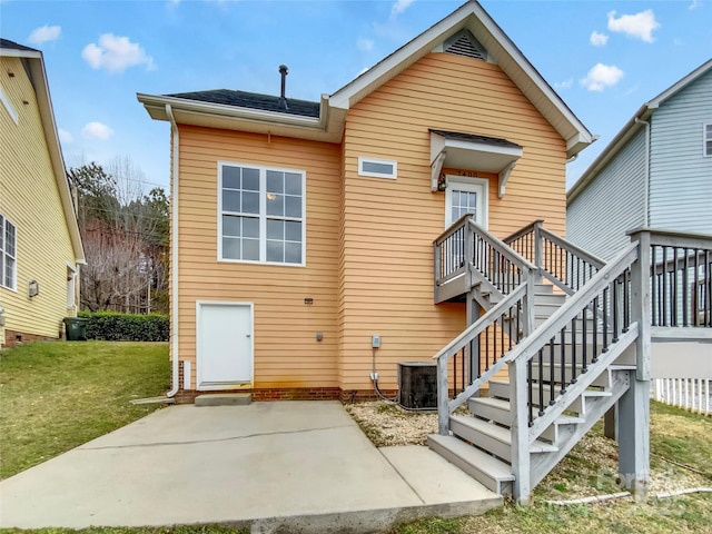 back of house featuring central AC unit, a lawn, stairway, roof with shingles, and a patio area