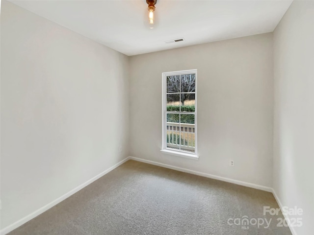 unfurnished room with baseboards, visible vents, and carpet flooring