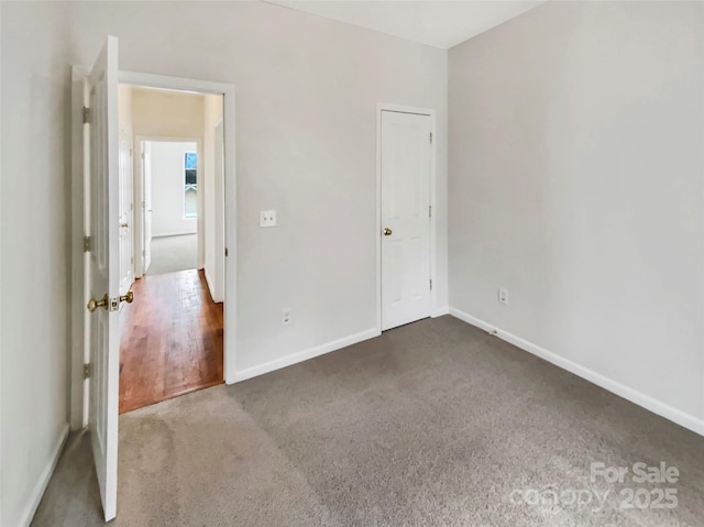 unfurnished bedroom featuring carpet and baseboards