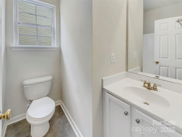 bathroom with vanity, toilet, and baseboards