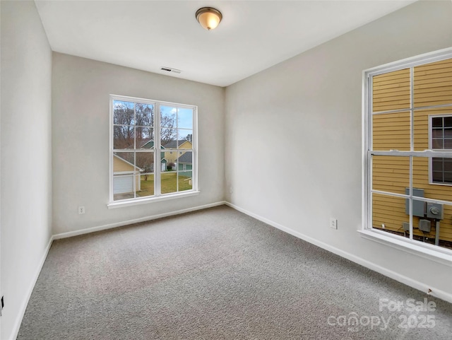 carpeted empty room featuring visible vents and baseboards