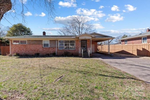 ranch-style house with driveway, fence, a front lawn, a carport, and brick siding