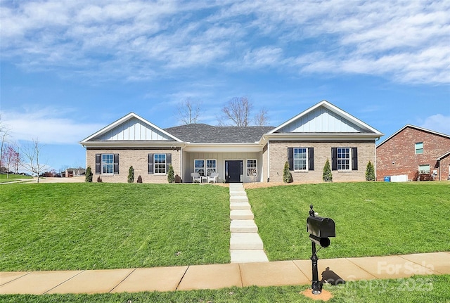 single story home featuring a front lawn, board and batten siding, and brick siding