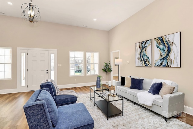 living area with an inviting chandelier, baseboards, wood finished floors, and recessed lighting