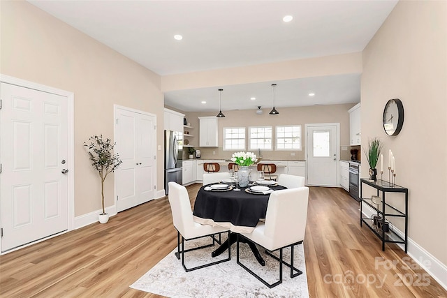 dining space with recessed lighting, light wood-style flooring, and baseboards