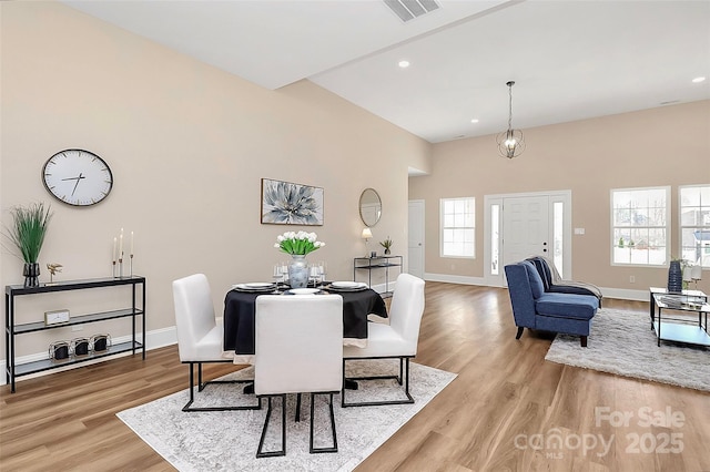 dining room with baseboards, visible vents, and light wood-style floors