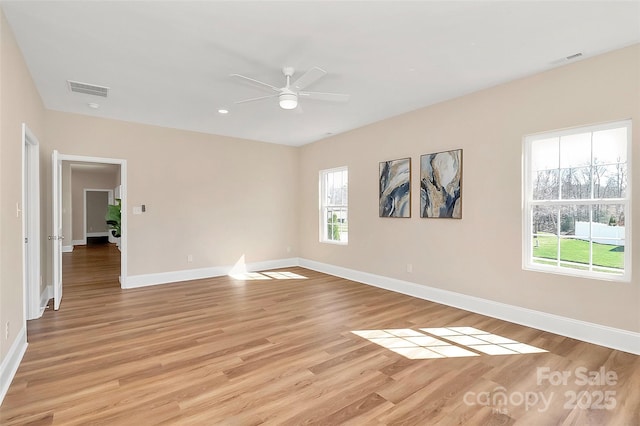 unfurnished room with light wood finished floors, baseboards, and visible vents