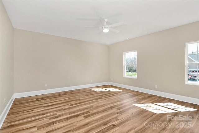 unfurnished room with a ceiling fan, baseboards, and light wood finished floors