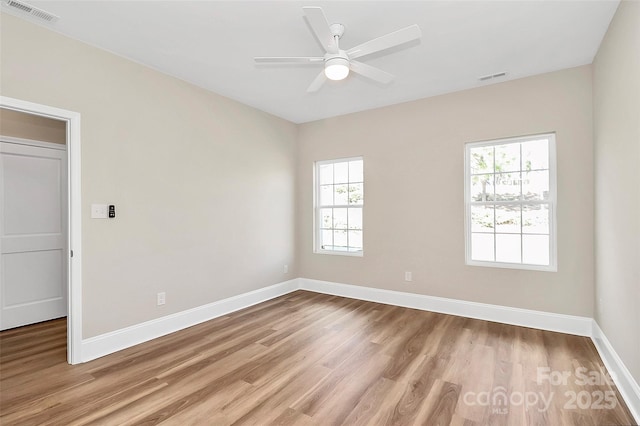 spare room with light wood-type flooring, baseboards, and visible vents