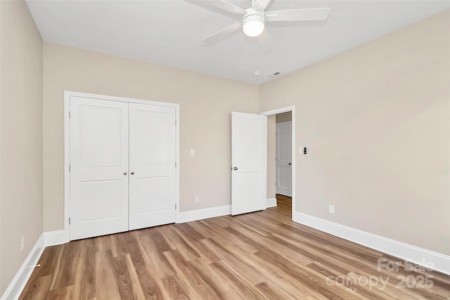 unfurnished bedroom with a closet, visible vents, light wood-style floors, ceiling fan, and baseboards