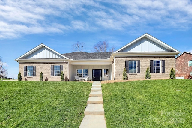 view of front of home with a front yard, board and batten siding, and brick siding