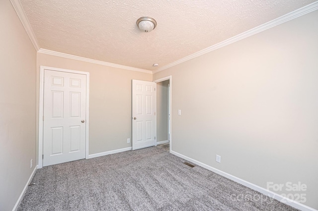 unfurnished bedroom with a textured ceiling, carpet flooring, visible vents, and baseboards