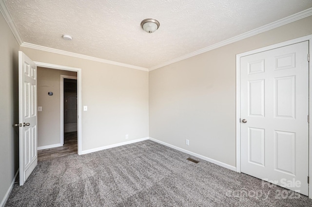 spare room with a textured ceiling, carpet floors, visible vents, and baseboards