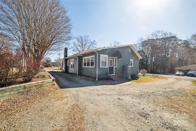 view of side of property featuring driveway and a chimney