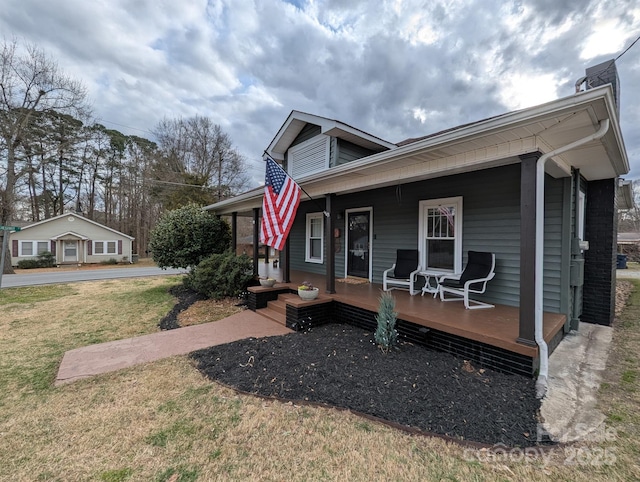 view of front of house with covered porch and a front lawn