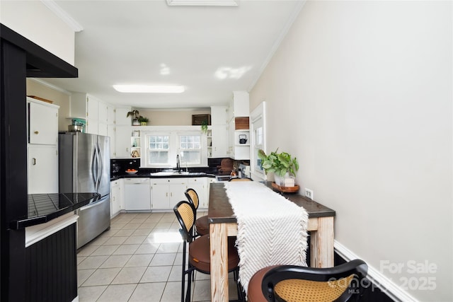 kitchen with light tile patterned floors, open shelves, ornamental molding, freestanding refrigerator, and dishwasher