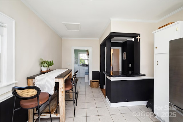 kitchen with tile countertops, crown molding, washer and clothes dryer, and light tile patterned floors