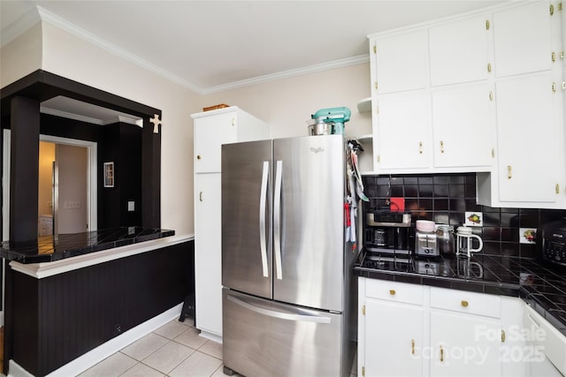 kitchen with tile countertops, light tile patterned flooring, white cabinetry, and freestanding refrigerator