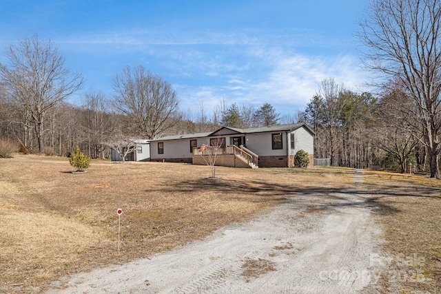 view of front facade featuring crawl space and dirt driveway