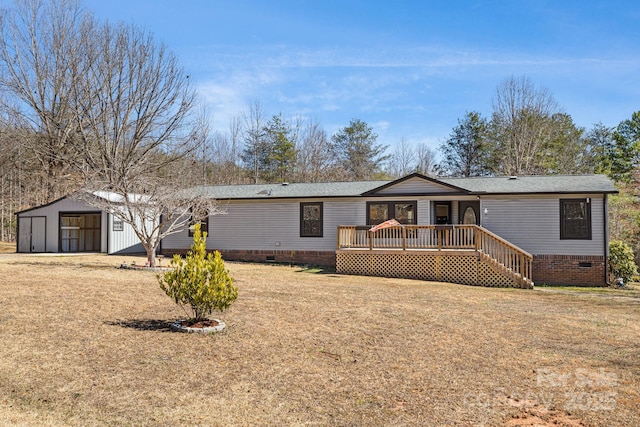 manufactured / mobile home with an outbuilding, crawl space, a front yard, and a wooden deck