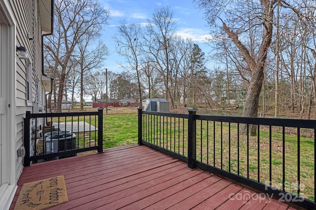 wooden deck with a fenced backyard, an outbuilding, cooling unit, a yard, and a shed