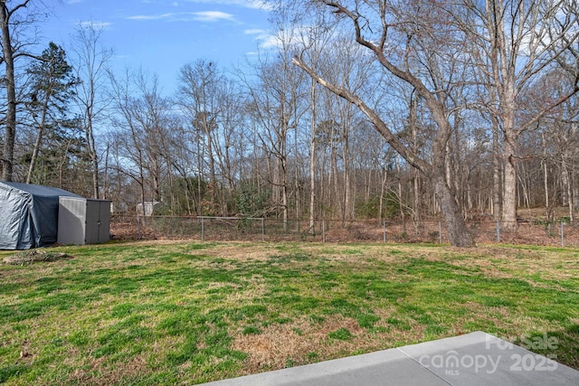 view of yard featuring an outbuilding and fence