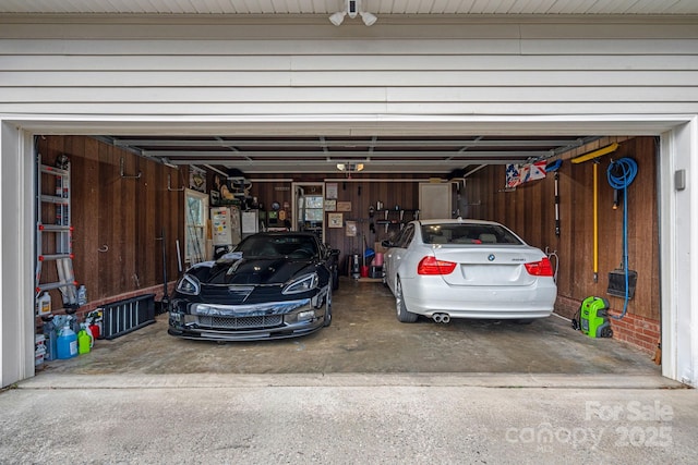 garage with water heater and wooden walls