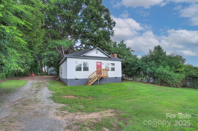 view of front facade featuring a chimney, driveway, crawl space, and a front yard