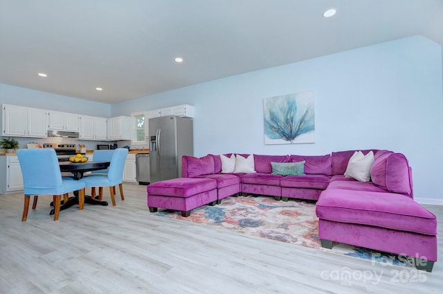 living area featuring lofted ceiling, recessed lighting, and light wood-style floors