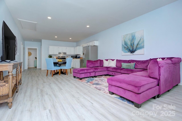 living area featuring light wood finished floors and recessed lighting