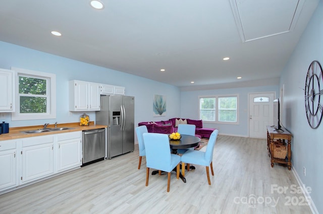 dining space with baseboards, light wood finished floors, and recessed lighting