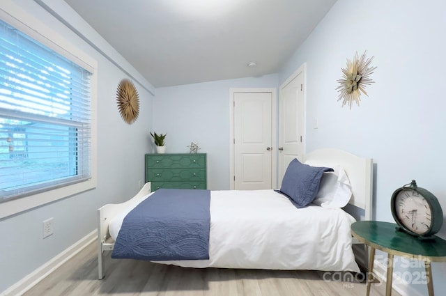 bedroom with baseboards and wood finished floors