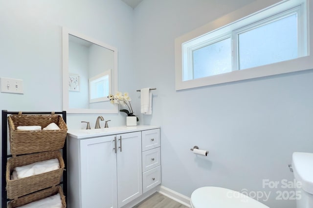 bathroom featuring wood finished floors, vanity, toilet, and baseboards