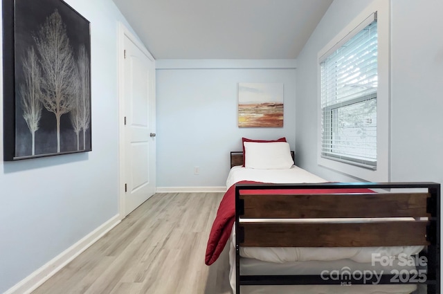 bedroom featuring wood finished floors and baseboards