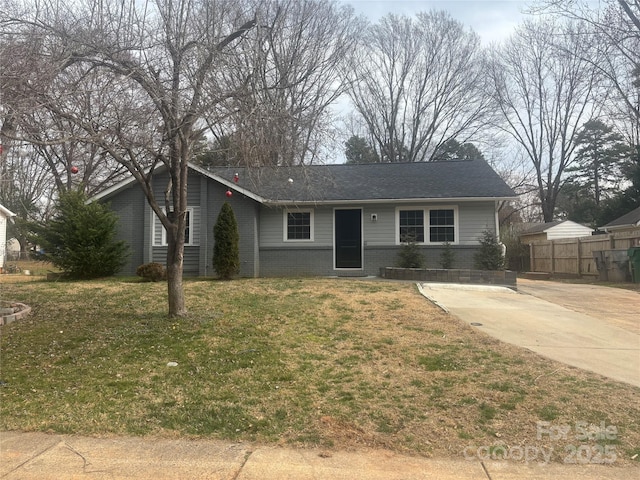 ranch-style house featuring driveway, fence, a front lawn, and brick siding