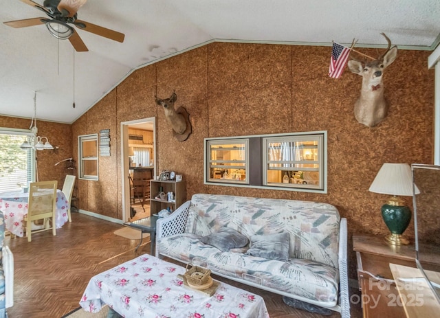 living area with a ceiling fan and lofted ceiling