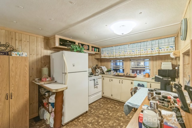 kitchen featuring open shelves, a sink, wooden walls, white appliances, and tile patterned floors