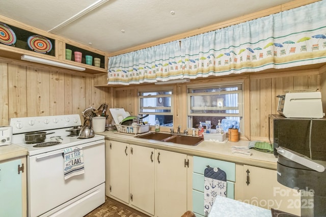 kitchen featuring a sink, electric stove, open shelves, and light countertops