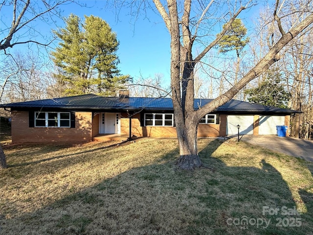 ranch-style home with driveway, brick siding, a chimney, metal roof, and a front yard