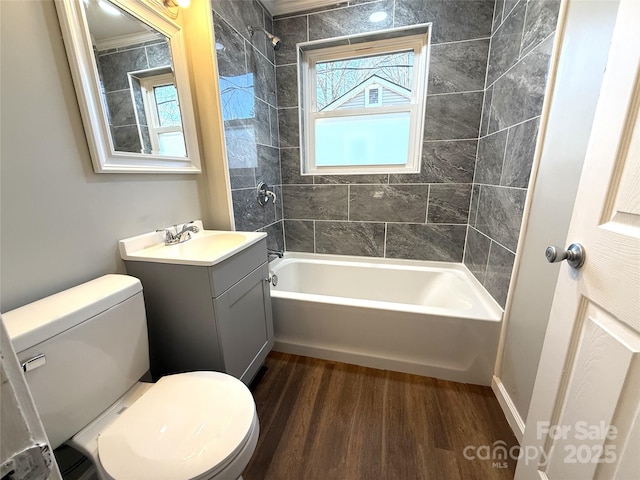 bathroom with washtub / shower combination, vanity, toilet, and wood finished floors