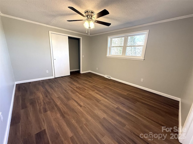 unfurnished bedroom with dark wood-style floors, visible vents, crown molding, and a textured ceiling