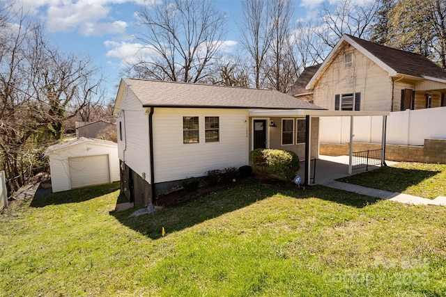 view of front of house featuring an outbuilding, a front lawn, fence, and a garage