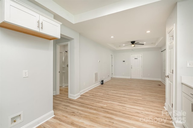 unfurnished room with baseboards, a tray ceiling, light wood-type flooring, and recessed lighting