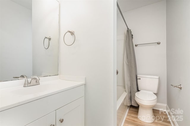 full bath featuring toilet, wood finished floors, vanity, baseboards, and shower / bath combination with curtain