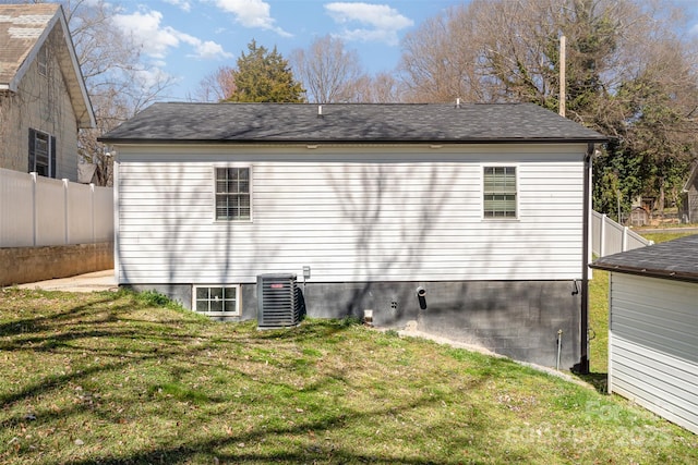 exterior space featuring central air condition unit, fence, and a yard