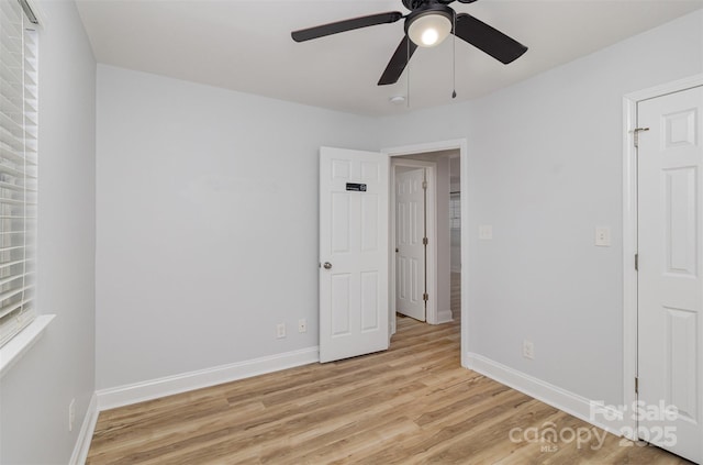 unfurnished bedroom featuring baseboards, a ceiling fan, and light wood-style floors