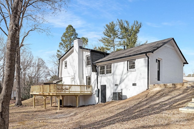 rear view of house featuring crawl space, brick siding, a chimney, and a wooden deck