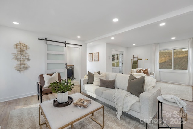 living area with washer / dryer, recessed lighting, light wood finished floors, and a barn door