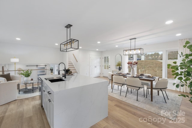 kitchen featuring light wood-type flooring, open floor plan, a sink, and recessed lighting